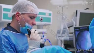 穿着医疗制服的医生做内窥镜检查.手术室内用新的医疗设备工作的外科医生的侧视图。医学新技术.